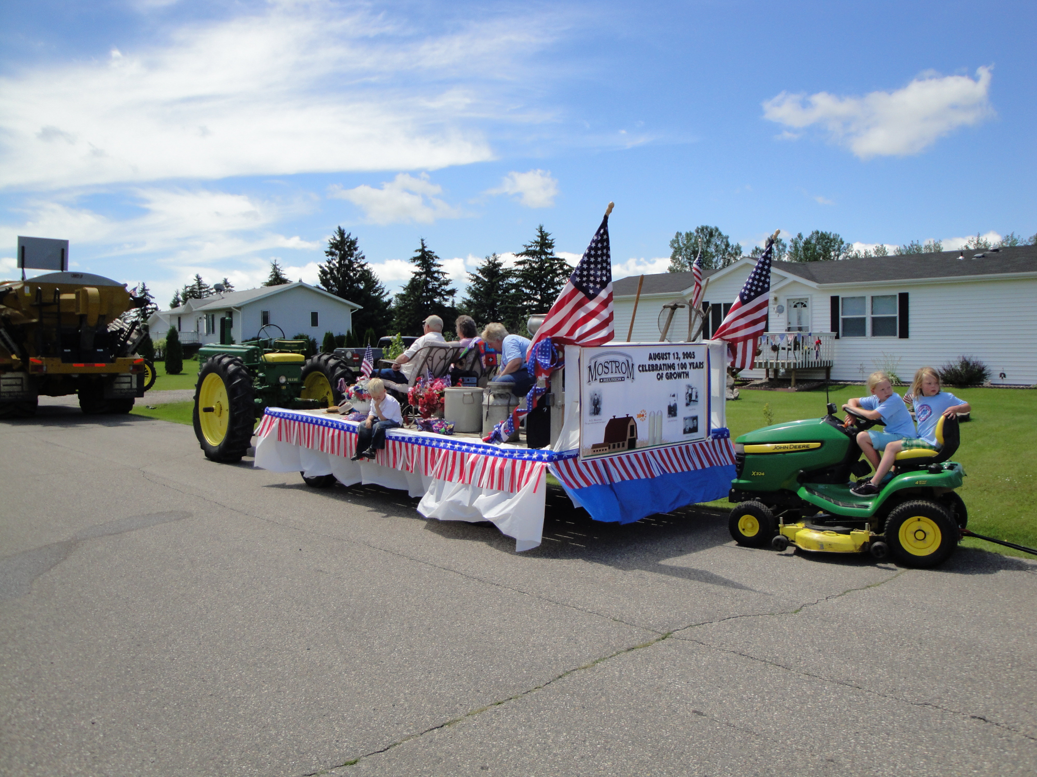 Olivia and Sofia driving JD mower in Oklee parade
